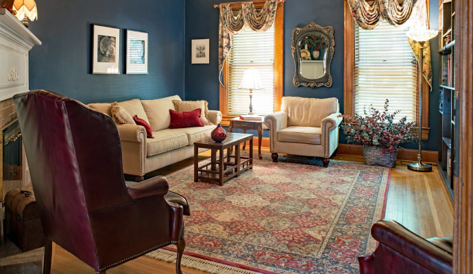 a living room floor is covered by a large patterned area rug  