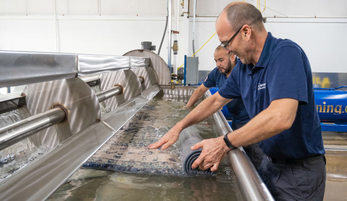 Professional cleaning rug using a professional washing machine in a factory setting