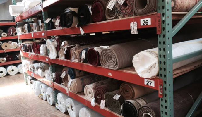 storage rack filled with numerous rolled rugs