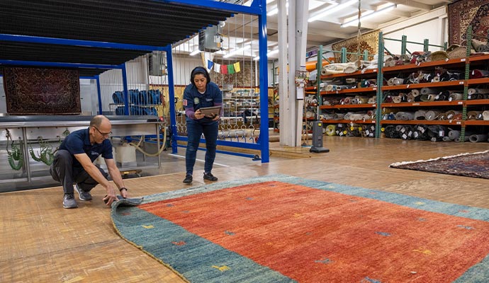two professional inspecting a rug