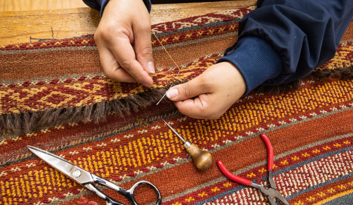 Professional repairing rug fringe using equipment