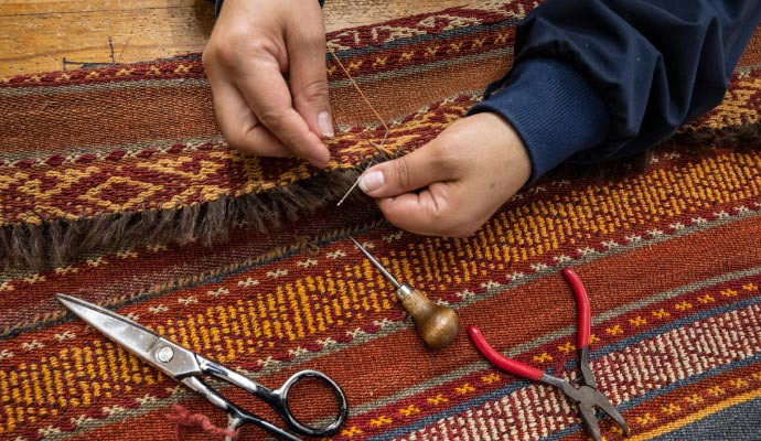 Expert repairing rug using equipment