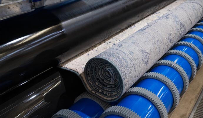 Rug cleaning using specialized machine in a factory setting