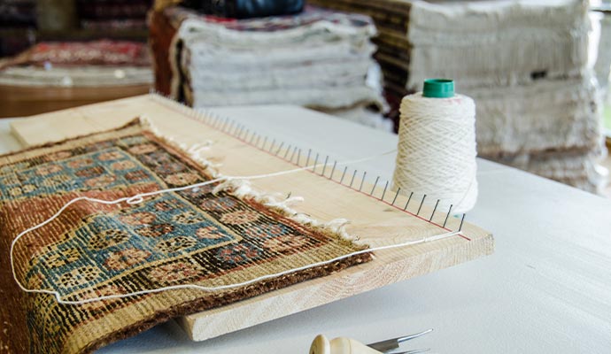 Repairing rug with damaged fringe.