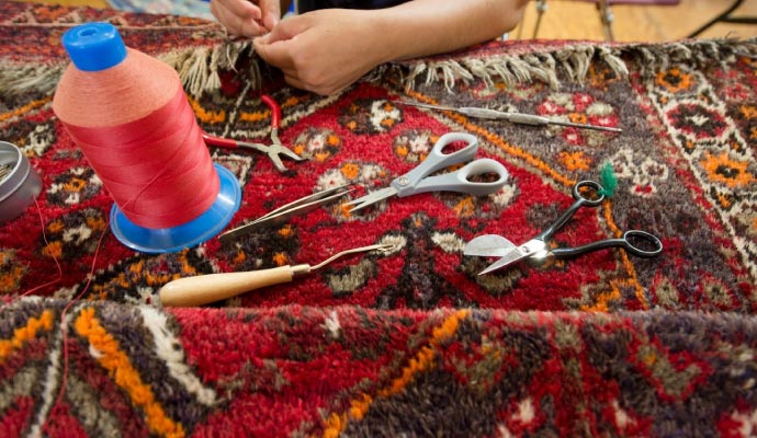 Expert repairing rug using equipment